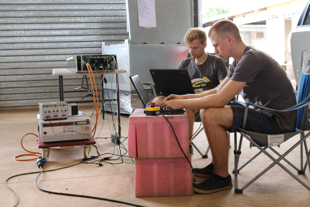 Samen met een teamlid is Bas Groenen de batterij van de zonneauto aan het testen.